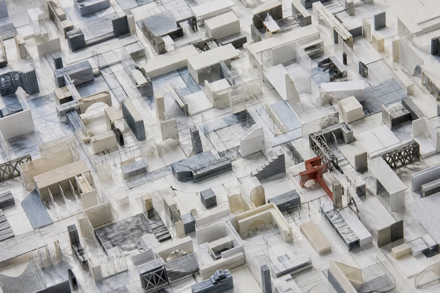 A hand-built field of architectural fragments with a small red structural joint.